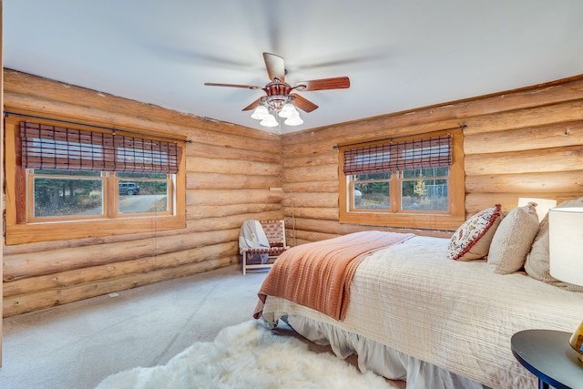 bedroom with ceiling fan, carpet floors, and rustic walls