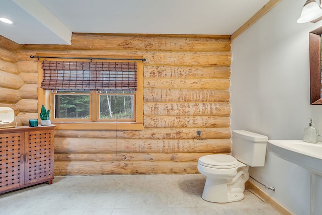 bathroom featuring rustic walls and toilet