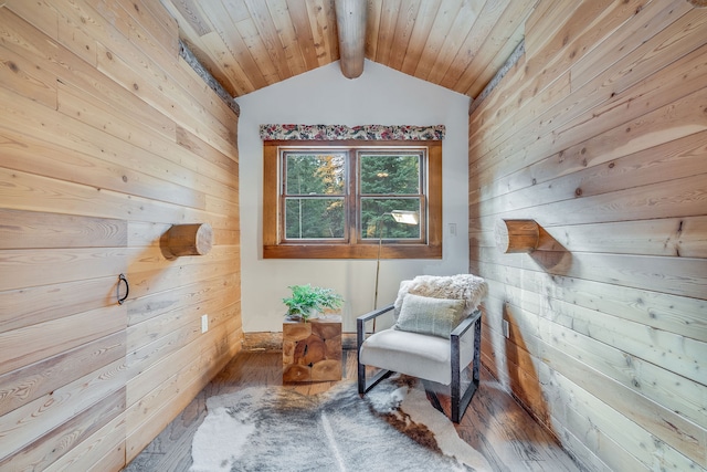 living area featuring hardwood / wood-style flooring, lofted ceiling with beams, and wood walls