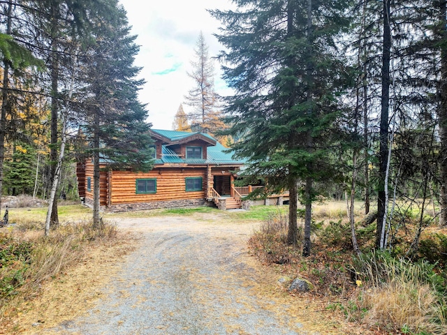 1750 Hill Meadows Rd, Whitefish, MT 59937 - log cabin with driveway, a porch, metal roof, and log siding