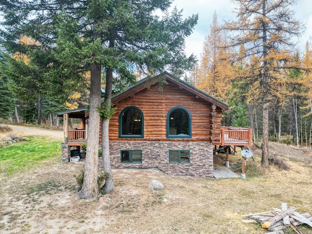 1750 Hill Meadows Rd, Whitefish, MT 59937 - view of side of property with a deck, a view of trees, and log exterior