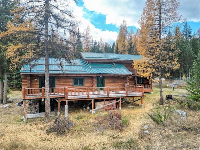 1750 Hill Meadows Rd, Whitefish, MT 59937 - rear view of house with log exterior, metal roof, and a wooden deck