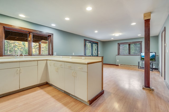 kitchen with sink, kitchen peninsula, and light wood-type flooring