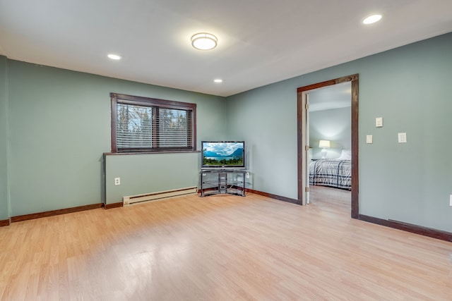 spare room with a baseboard radiator and light hardwood / wood-style floors