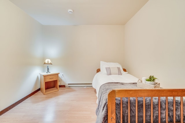 bedroom featuring a baseboard radiator and light wood-type flooring