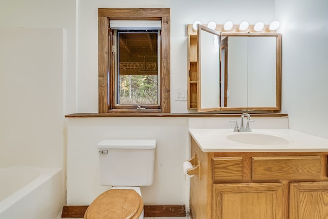 bathroom with vanity, a tub, and toilet