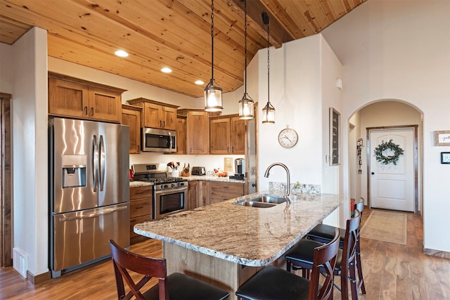 kitchen featuring appliances with stainless steel finishes, sink, hanging light fixtures, wooden ceiling, and high vaulted ceiling