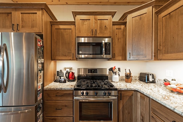 kitchen featuring appliances with stainless steel finishes and light stone counters