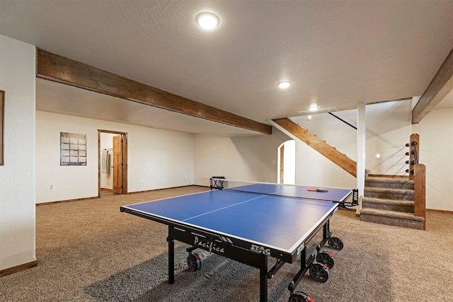 recreation room featuring a textured ceiling, carpet, and beamed ceiling