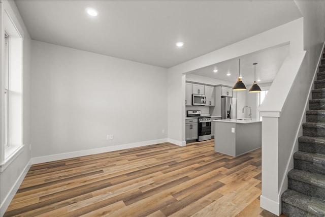 unfurnished living room featuring hardwood / wood-style floors and sink