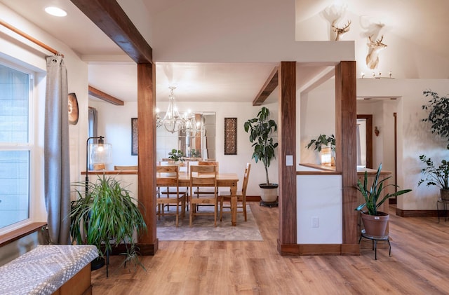 dining room featuring an inviting chandelier, beam ceiling, and light hardwood / wood-style flooring