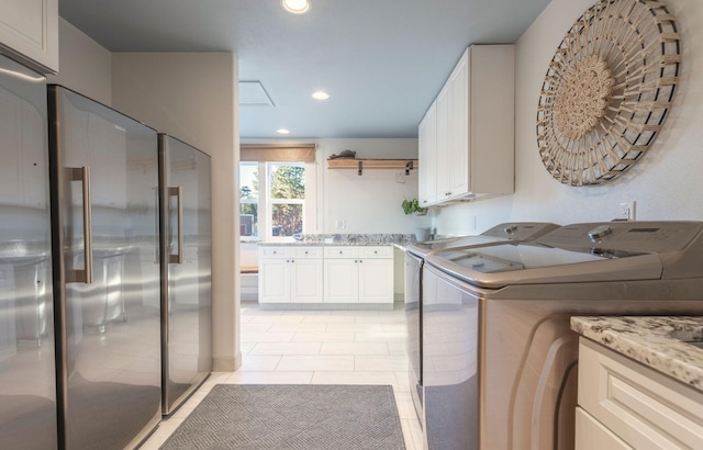 washroom featuring cabinets, washer and dryer, and light tile patterned flooring