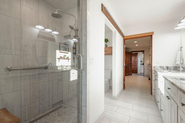 bathroom with walk in shower, vanity, and toilet