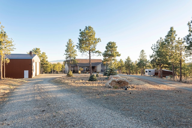 view of front of house featuring a garage and an outbuilding