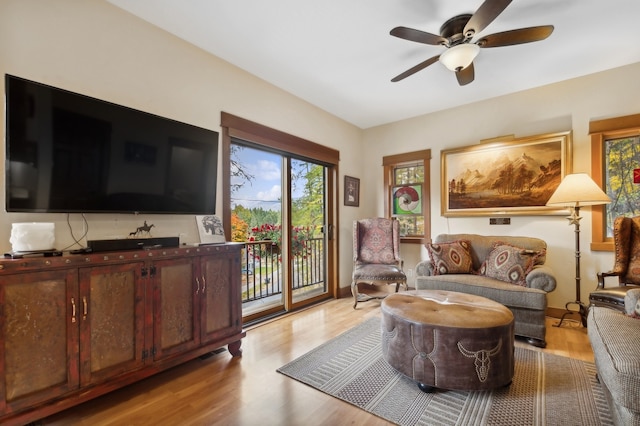 living room with light hardwood / wood-style flooring and ceiling fan