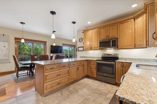 kitchen with light hardwood / wood-style floors, stainless steel appliances, kitchen peninsula, sink, and pendant lighting