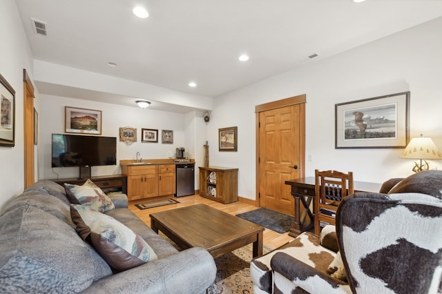 living room featuring light hardwood / wood-style flooring and wet bar