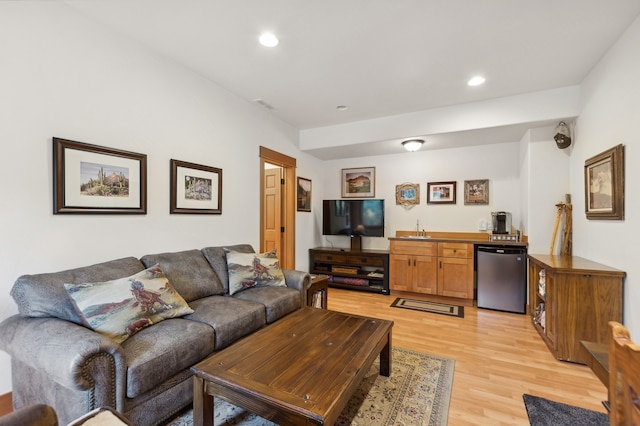 living room with light hardwood / wood-style flooring and wet bar