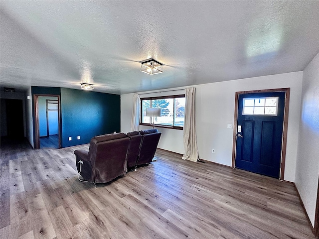 living room featuring light hardwood / wood-style floors, a textured ceiling, and a wealth of natural light