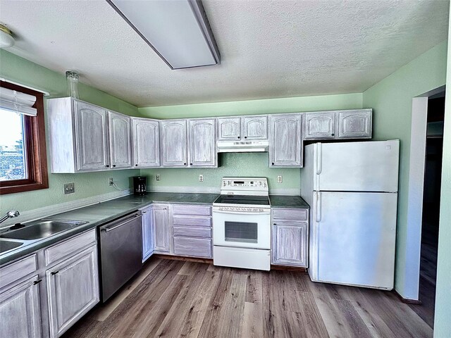 kitchen with a textured ceiling, light wood-type flooring, and white appliances