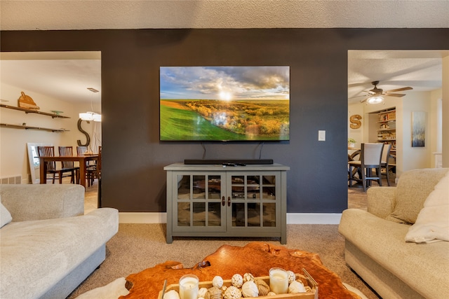 carpeted living room with ceiling fan and a textured ceiling