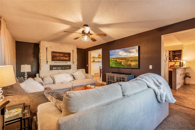 carpeted living room featuring ceiling fan and a textured ceiling