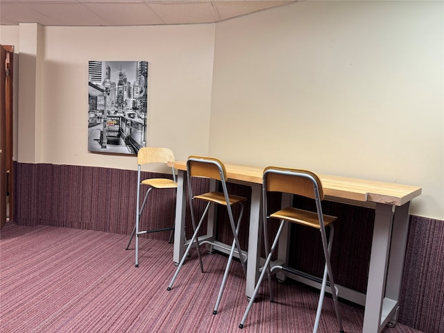 carpeted dining room with a paneled ceiling