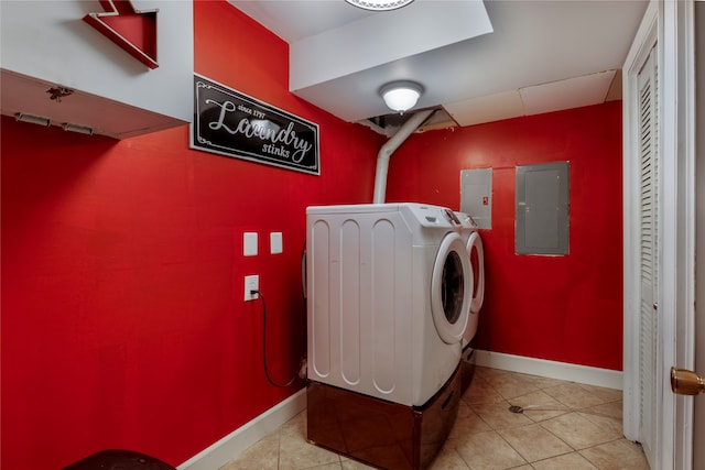 washroom featuring light tile patterned flooring, washing machine and clothes dryer, and electric panel