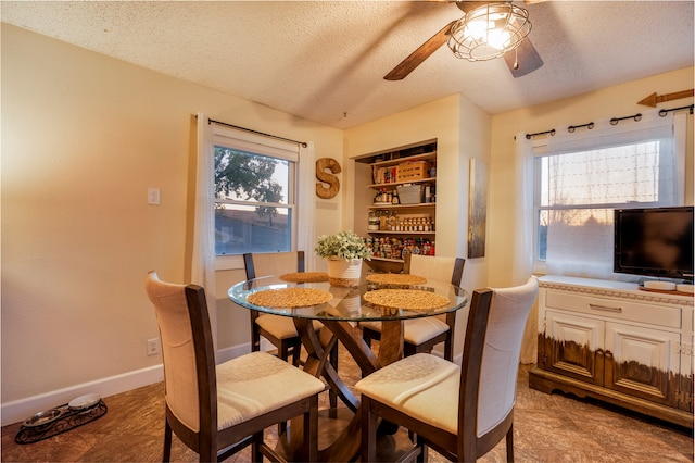 dining space featuring built in shelves, ceiling fan, plenty of natural light, and a textured ceiling