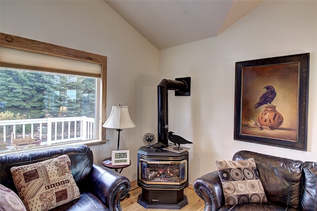 living room featuring hardwood / wood-style flooring, a wood stove, and lofted ceiling