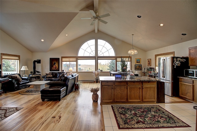 kitchen with a wealth of natural light, light hardwood / wood-style flooring, pendant lighting, and appliances with stainless steel finishes