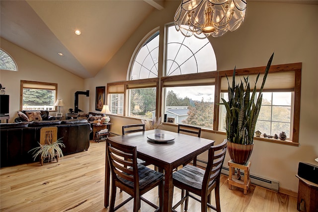 dining room with high vaulted ceiling, a baseboard radiator, a notable chandelier, and light wood-type flooring