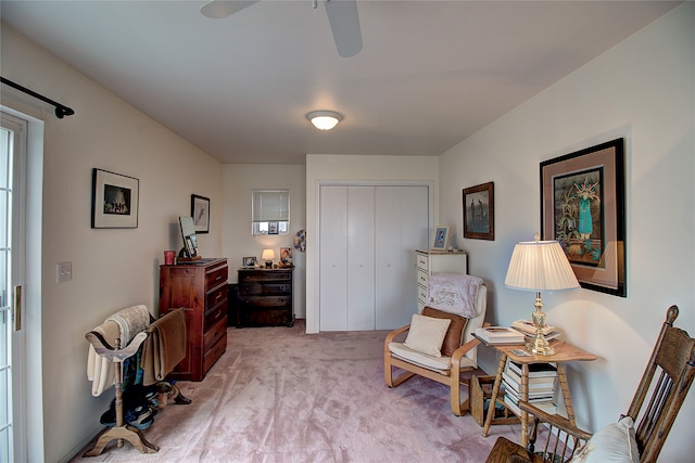 sitting room with ceiling fan and light colored carpet