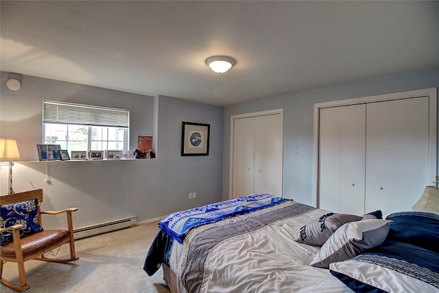 carpeted bedroom featuring baseboard heating and multiple closets