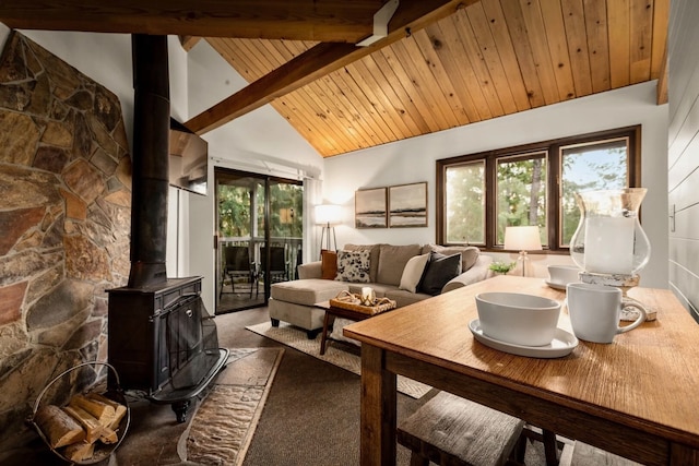 dining room with wood ceiling, beam ceiling, high vaulted ceiling, dark carpet, and a wood stove