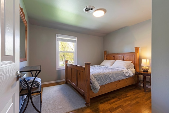 bedroom with dark hardwood / wood-style floors