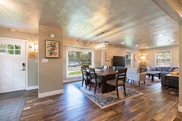 dining area featuring a textured ceiling, dark hardwood / wood-style floors, and plenty of natural light