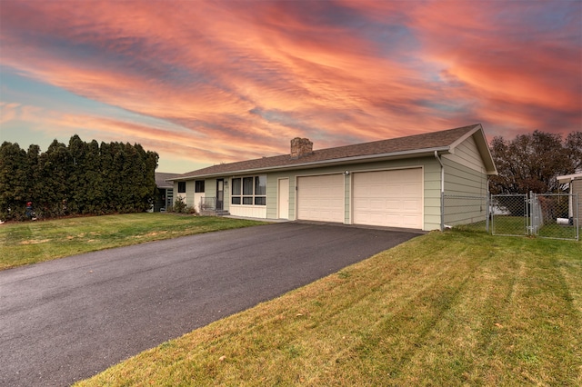 ranch-style home with a yard and a garage