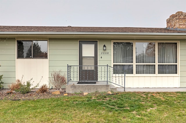 doorway to property with a lawn