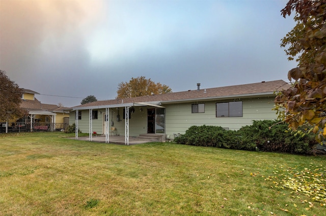 rear view of house featuring a patio and a yard