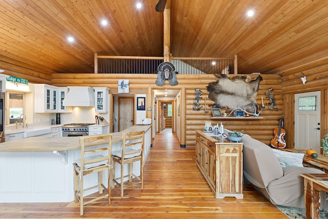 2197 W Tower Rd, Saltese, MT 59867 - kitchen featuring wooden ceiling, custom exhaust hood, a sink, high end stove, and light wood-style floors