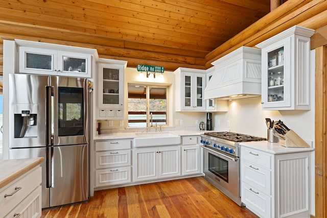 2197 W Tower Rd, Saltese, MT 59867 - kitchen with stainless steel appliances, custom range hood, a sink, wood ceiling, and vaulted ceiling