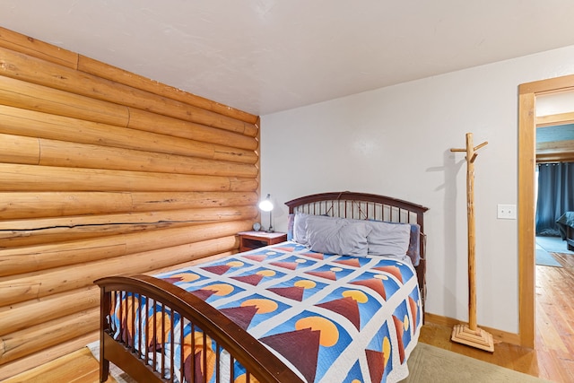 2197 W Tower Rd, Saltese, MT 59867 - bedroom featuring rustic walls, wood finished floors, and baseboards