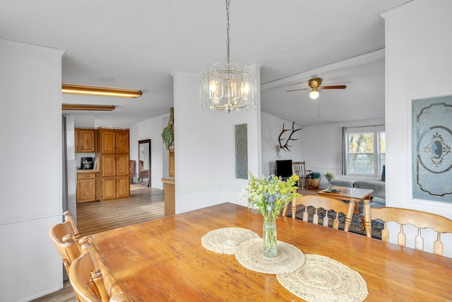 dining space with light hardwood / wood-style flooring, a textured ceiling, ceiling fan with notable chandelier, and crown molding