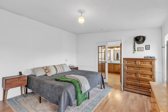 bedroom featuring light hardwood / wood-style floors and a textured ceiling