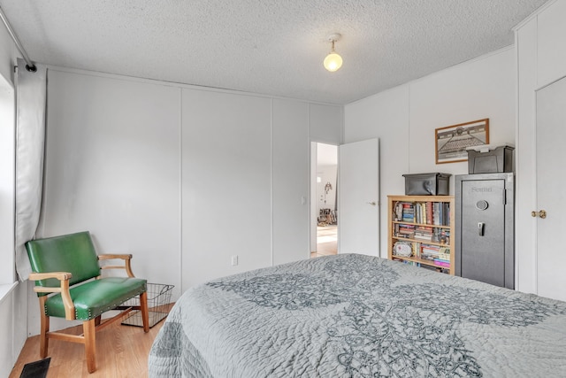 bedroom with light hardwood / wood-style flooring and a textured ceiling