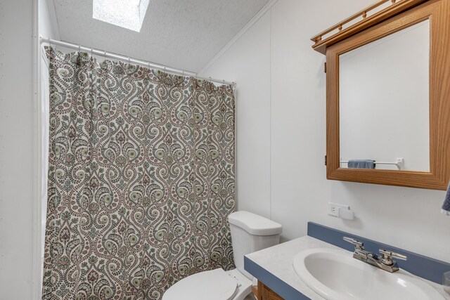 bathroom featuring toilet, ornamental molding, vanity, a textured ceiling, and a skylight