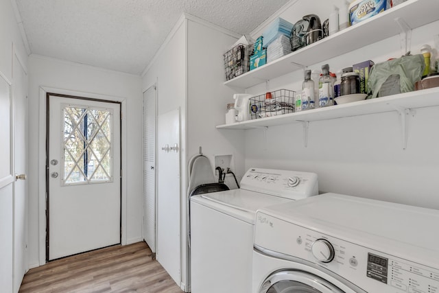 washroom featuring light hardwood / wood-style floors, crown molding, a textured ceiling, and separate washer and dryer