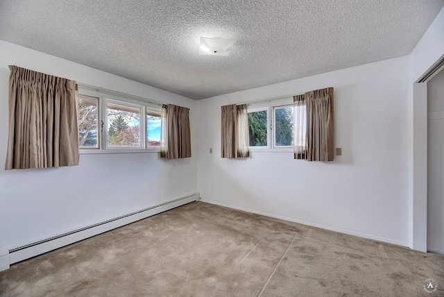 carpeted empty room featuring a textured ceiling and a baseboard radiator