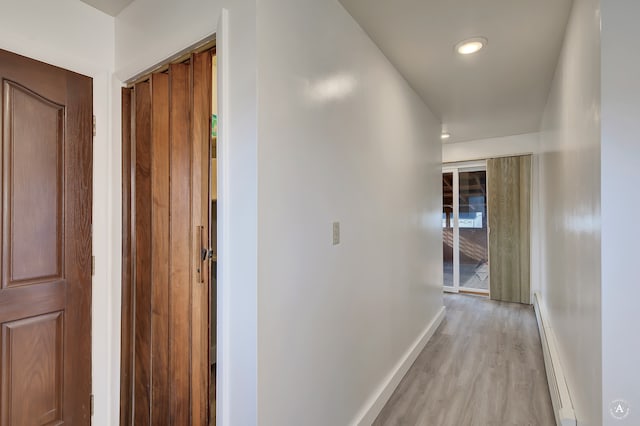 corridor featuring light hardwood / wood-style flooring and baseboard heating